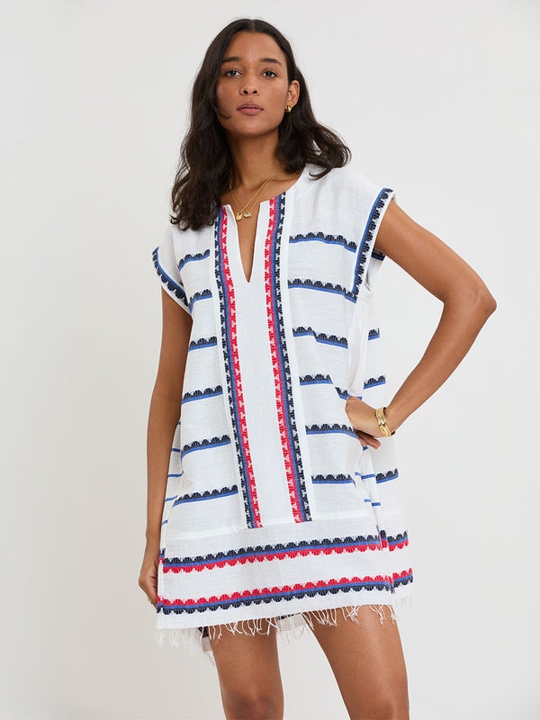 Woman Standing wearing lemlem handwoven ELINA Caftan featuring a playful, preppy scalloped Tibeb weave with classic navy, red, and vibrant blue accents.