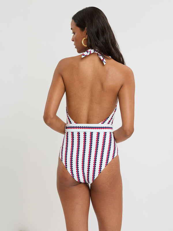 Woman Standing wearing lemlem LIDYA One Piece featuring a playful, preppy scalloped Tibeb weave with classic navy, red, and vibrant blue accents.