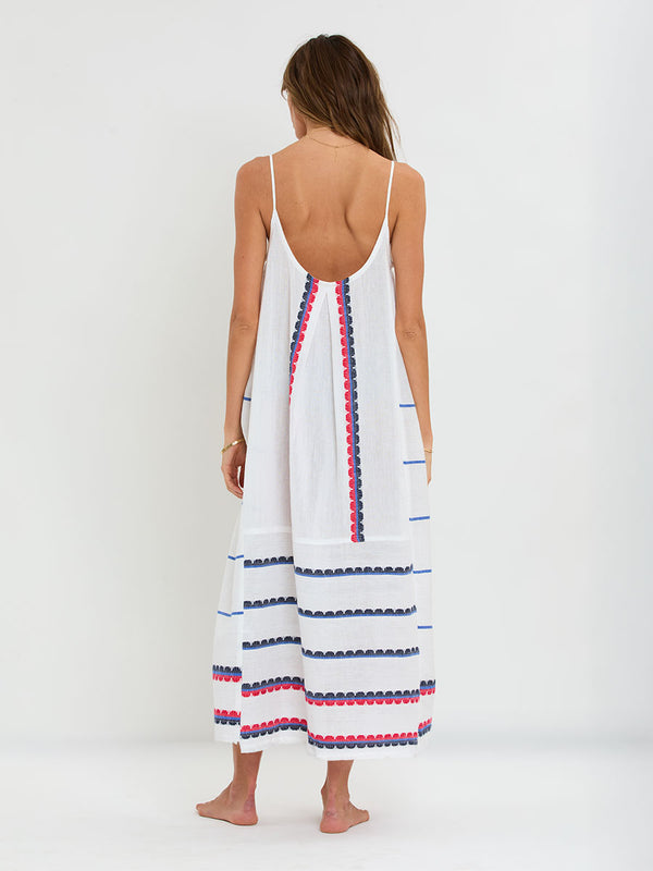 Woman Standing wearing lemlem handwoven NIA Dress featuring a playful, preppy scalloped Tibeb weave with classic navy, red, and vibrant blue accents.