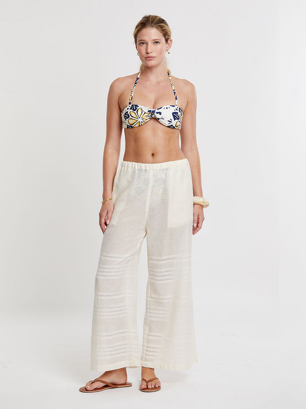 Woman standing wearing lemlem handwoven DESTA Pants featuring extra light gauzy cotton in a delicate cream color.