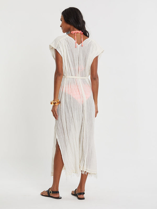 Woman standing wearing lemlem handwoven JANENE Dress featuring extra light gauzy cotton in a delicate cream color.