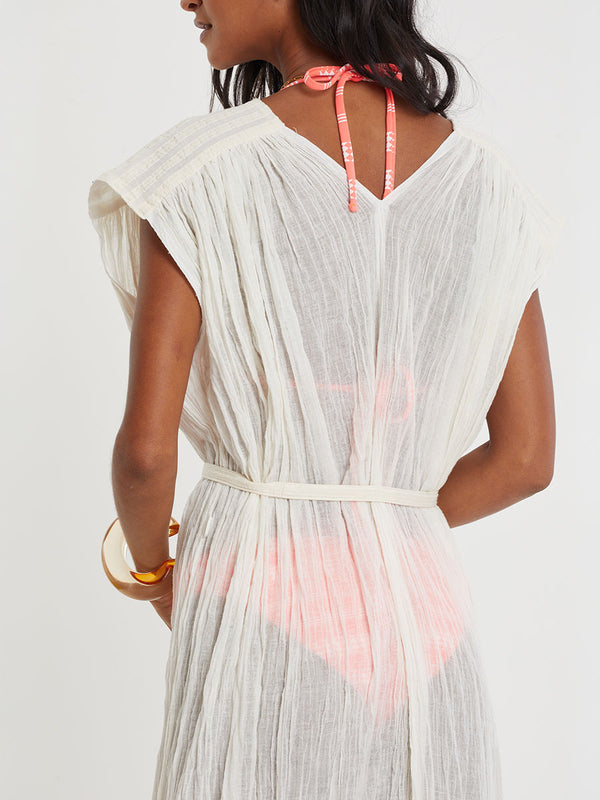 Woman standing wearing lemlem handwoven JANENE Dress featuring extra light gauzy cotton in a delicate cream color.