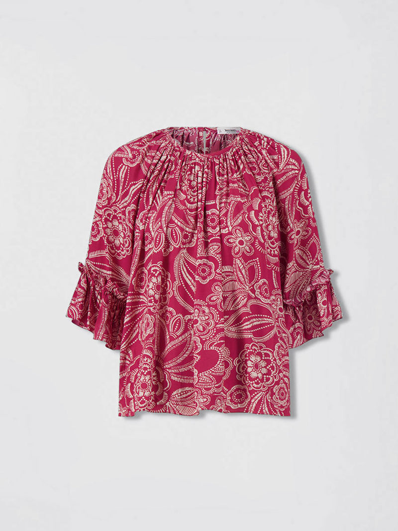 Product front shot of  lemlem MONIKA Blouse featuring rich ruby-red fabric  adorned with intricate white floral and leaf motifs print