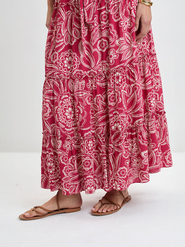 Close up on a Woman Standing Wearing lemlem MUNA Crop Top and SANAA Skirt featuring rich burgundy fabric with white leaf print