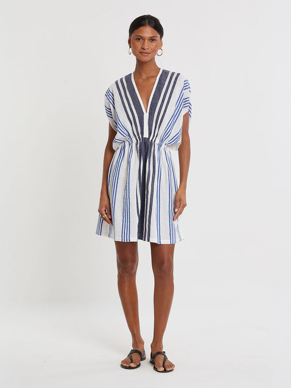 Woman wearing lemlem handwoven ALEM Dress featuring bold two-tone stripes in classic navy, blue colors on crispy white background.
