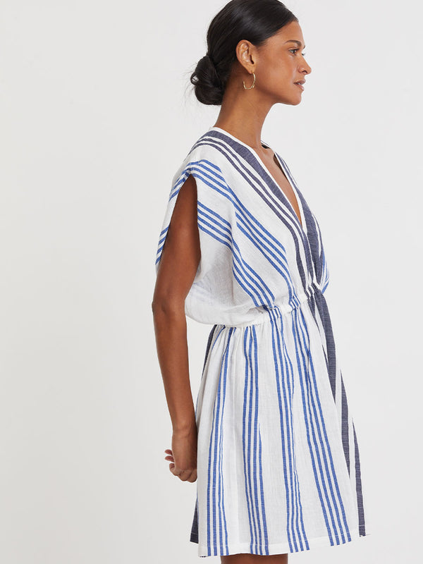 Woman wearing lemlem handwoven ALEM Dress featuring bold two-tone stripes in classic navy, blue colors on crispy white background.