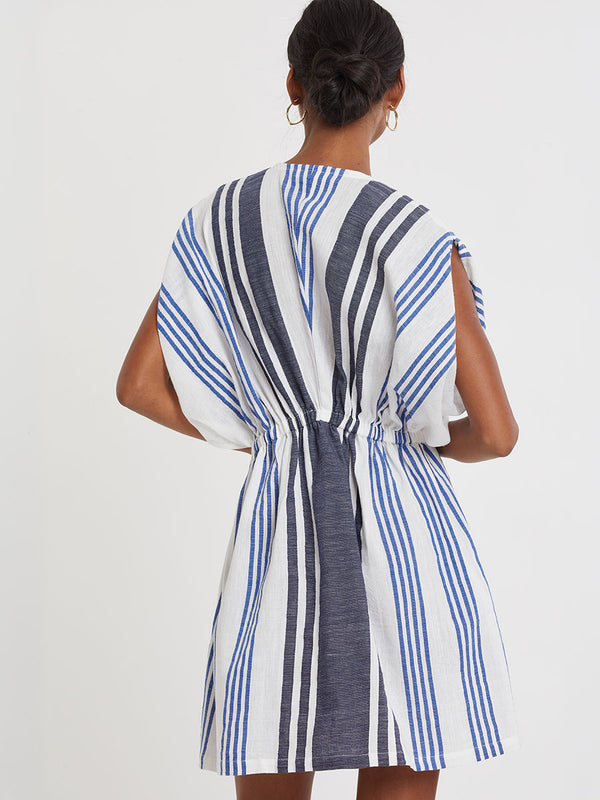 Woman wearing lemlem handwoven ALEM Dress featuring bold two-tone stripes in classic navy, blue colors on crispy white background.