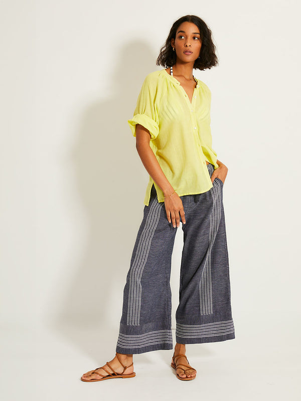Woman Standing Wearing lemlem DESTA Pants featuring chambray navy color accented with fine, textured white stripes
