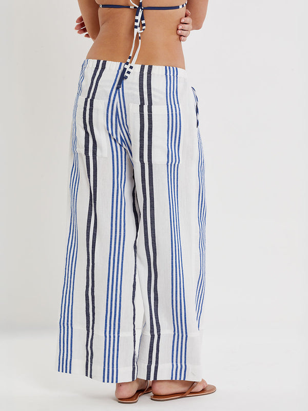 Woman wearing lemlem handwoven DESTA Pants  featuring bold two-tone stripes in classic navy, blue colors on crispy white background.