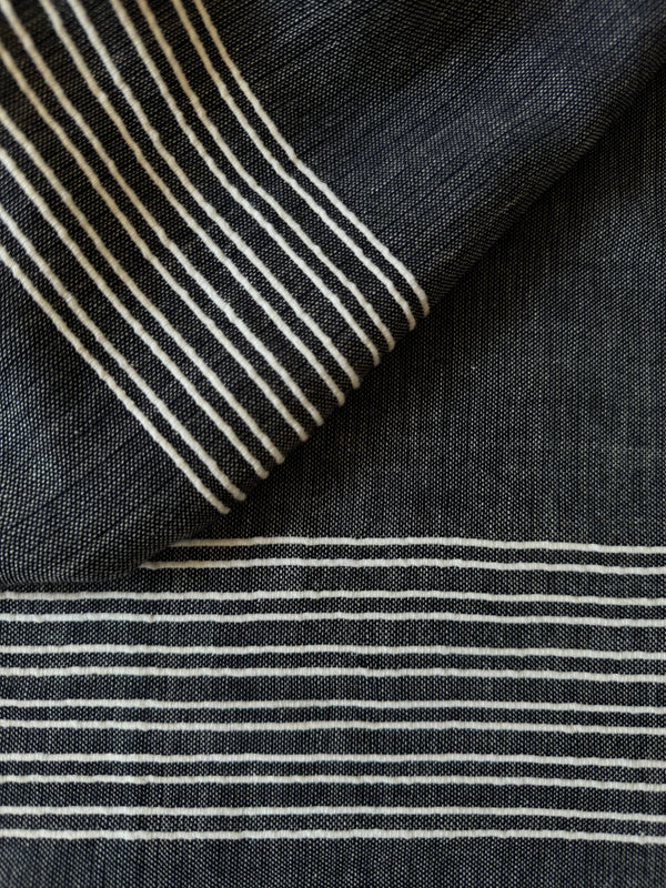 close up on lemlem MARI Navy Fabric featuring chambray navy color accented with fine, textured white stripes
