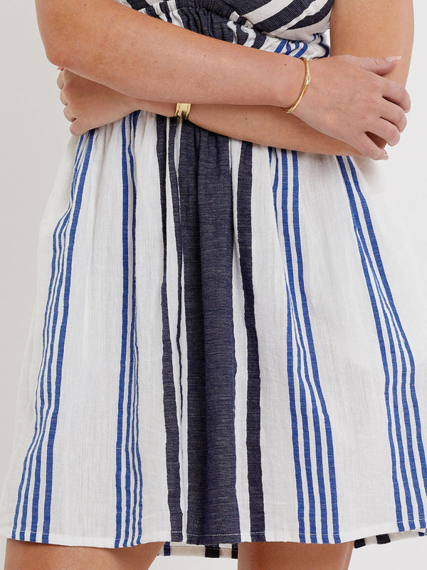 Woman wearing lemlem handwoven KAYLA Dress featuring bold two-tone stripes in classic navy, blue colors on crispy white background.