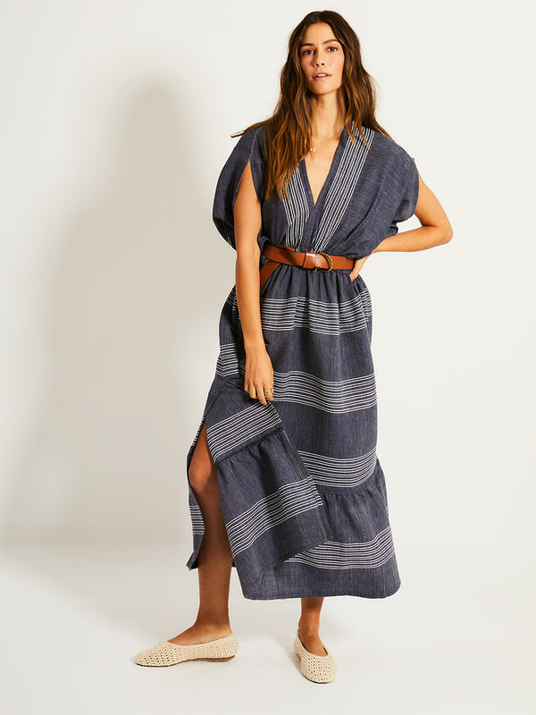Woman Standing Wearing lemlem  LEILA Dress  featuring chambray navy color accented with fine, textured white stripes