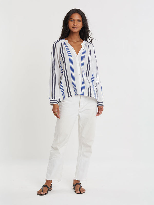 Woman wearing lemlem handwoven MITA Blouse featuring bold two-tone stripes in classic navy, blue colors on crispy white background.
