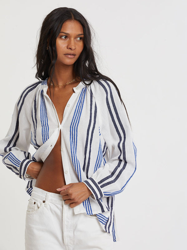 Woman wearing lemlem handwoven MITA Blouse featuring bold two-tone stripes in classic navy, blue colors on crispy white background.
