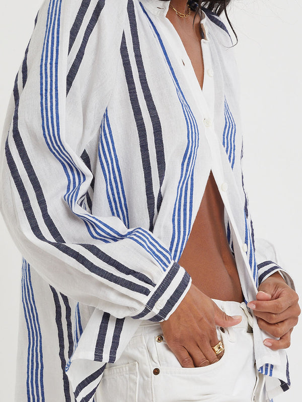 Woman wearing lemlem handwoven MITA Blouse featuring bold two-tone stripes in classic navy, blue colors on crispy white background.