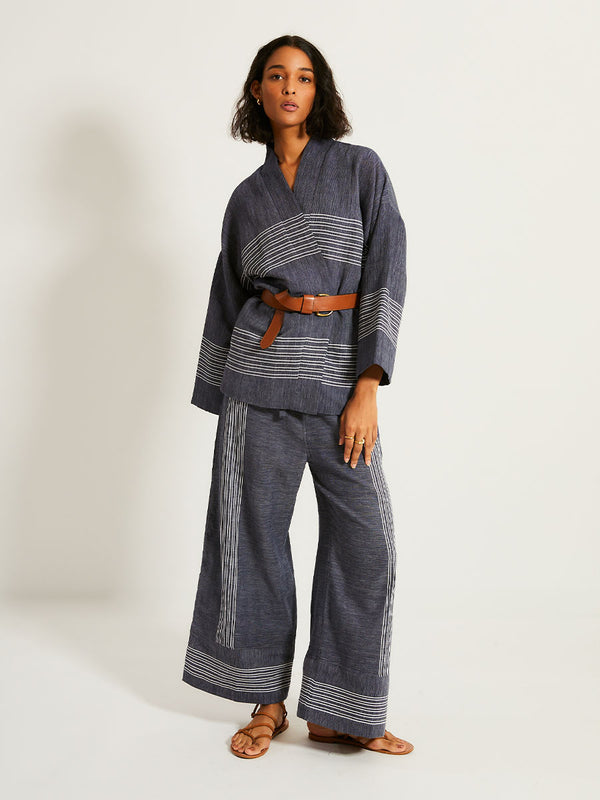 Woman Standing Wearing lemlem TERARA Jacket  featuring chambray navy color accented with fine, textured white stripes