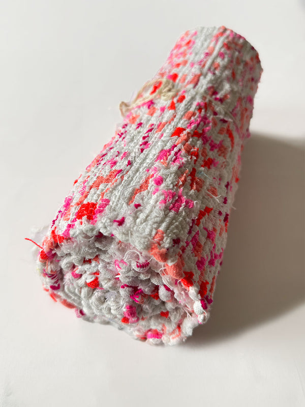 Product Shot of rolled lemlem Eshe Pink Rug featuring pink, orange and white colors