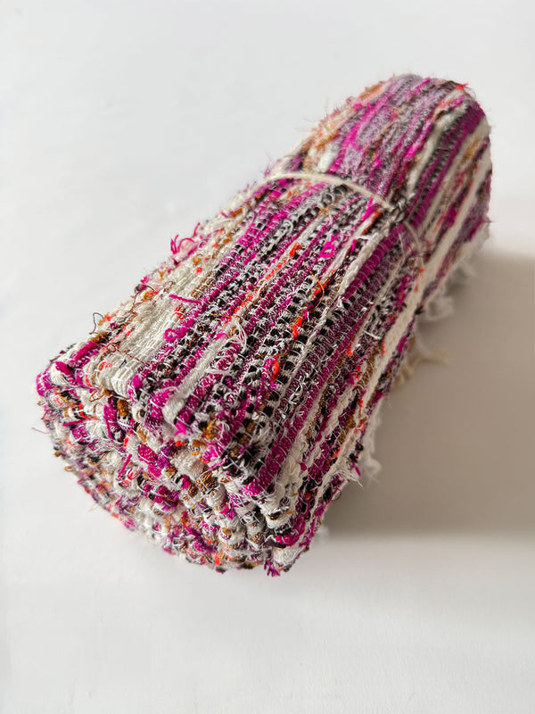 Product Shot of rolled lemlem Genet Bery rug featuring Cream, Magenta, Black and Orange Colors