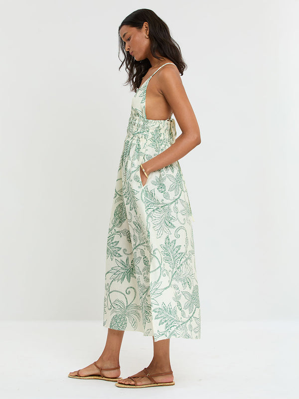 Woman Standing wearing lemlem GETE Dress featuring a custom, hand-drawn tropical pineapple motif in a tropical green hue on an ivory background.