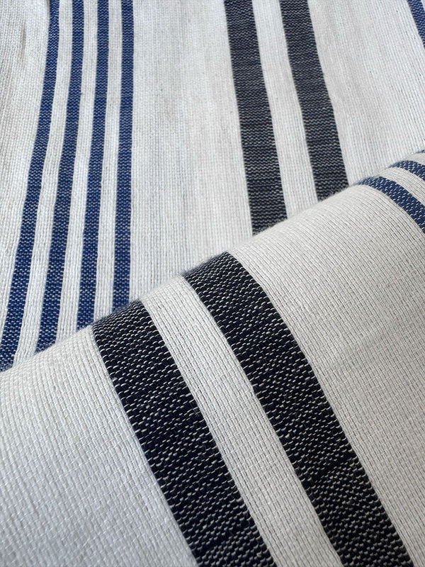 Close-up of a striped woven textile with alternating vertical bands of dark navy blue and off-white.