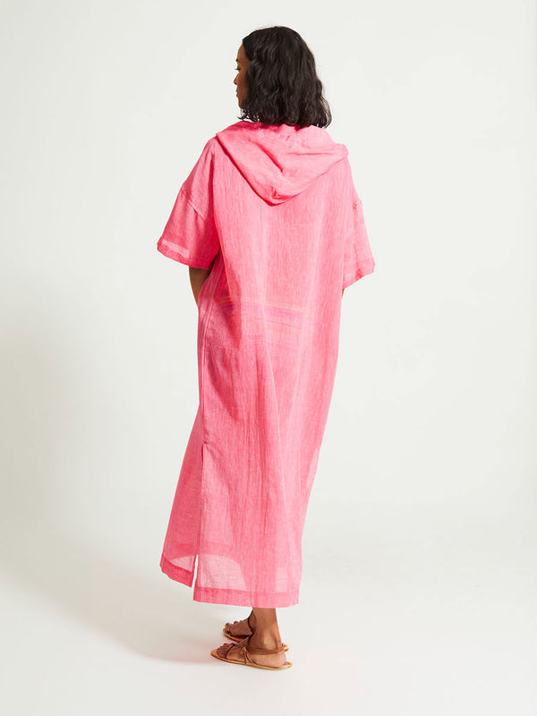 Back of a Woman Standing Wearing lemlem BERITU | Hoodie Dress featuring sheer fabric in pink watermelon color