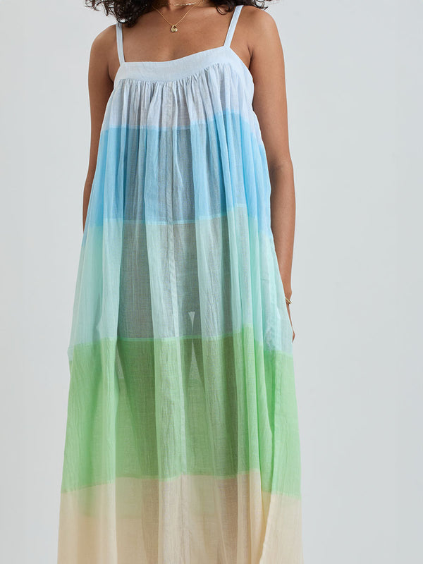Close up on a woman standing wearing EDA Dress featuring light blue, aqua, mint, soft green and cream