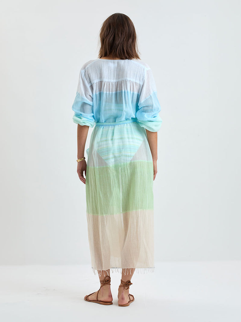 Back of a Woman wearing lemlem handwoven MATARA Robe featuring light, gauzy fabric with a beautiful color block of light blue, aqua, mint, soft green and cream