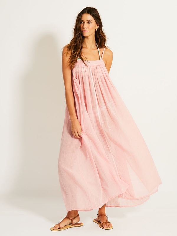 Woman Standing Wearing lemlem EDA Slip Dress featuring sheer fabric in soft rose color
