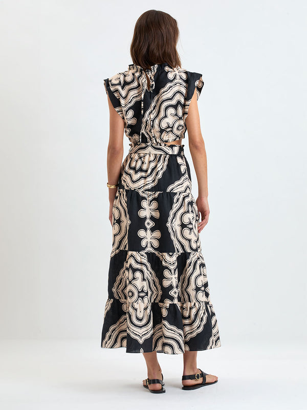 Woman wearing lemlem linen  SANAA Skirt featuring  a custom-designed print inspired by ancient architectural patterns in cream and black colors and a matching top