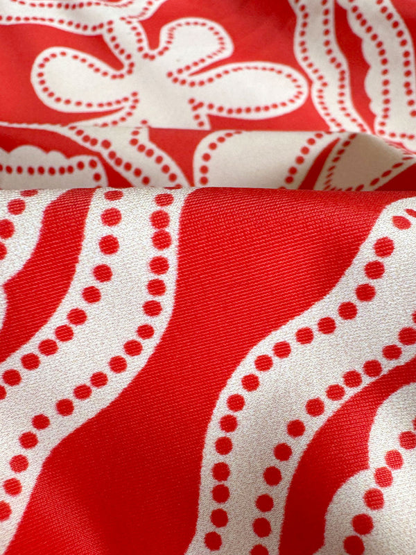 Close up on lemlem Niku Red fabric featuring custom-designed print inspired by ancient architectural patterns, blending the classic with the contemporary.