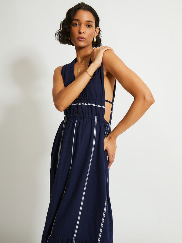 Woman Standing Wearing lemlem Lelisa Dress featuring delicate white Tibeb bands on a rich navy background