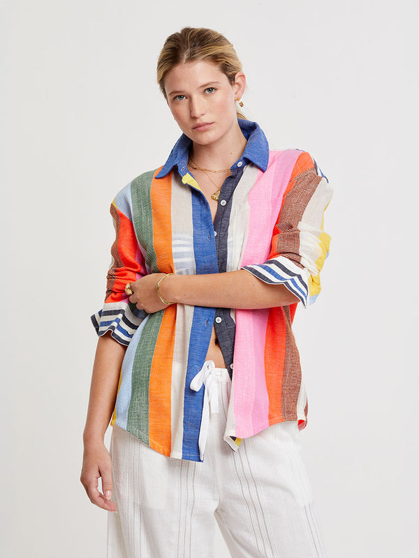 Woman wearing lemlem handwoven AISHA Shirt featuring bold, joyful stripe pattern in vibrant shades of blue, yellow, pink, orange, and green