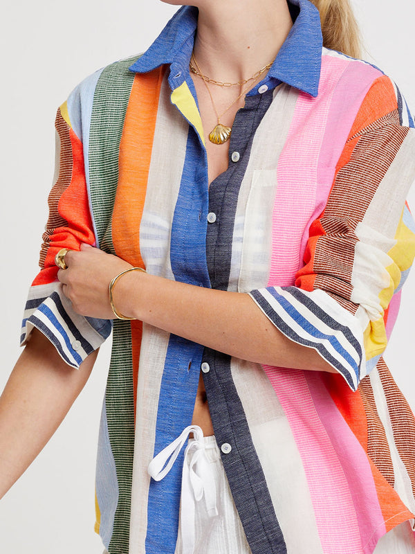 Woman wearing lemlem handwoven AISHA Shirt featuring bold, joyful stripe pattern in vibrant shades of blue, yellow, pink, orange, and green