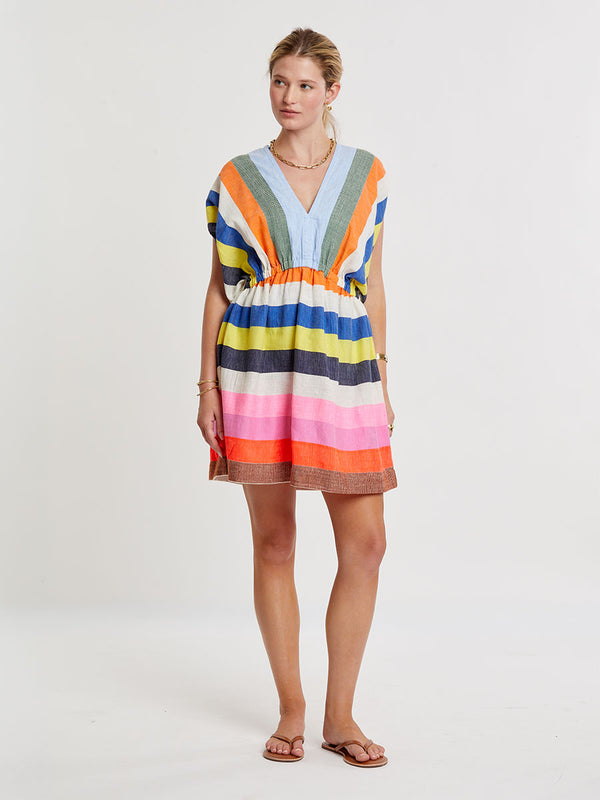 Woman wearing lemlem handwoven ALEM Plunge Dress featuring bold, joyful stripe pattern in vibrant shades of blue, yellow, pink, orange, and green
