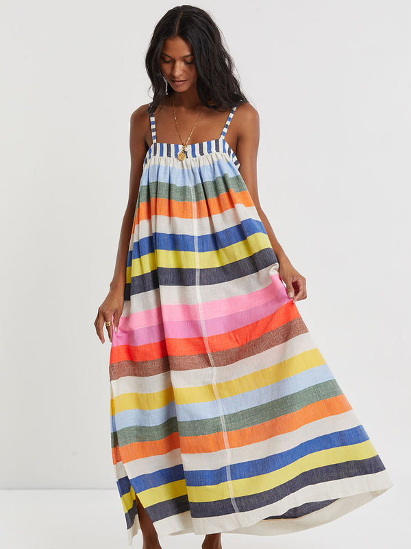 Woman wearing lemlem handwoven EDA Dress featuring bold, joyful stripe pattern in vibrant shades of blue, yellow, pink, orange, and green