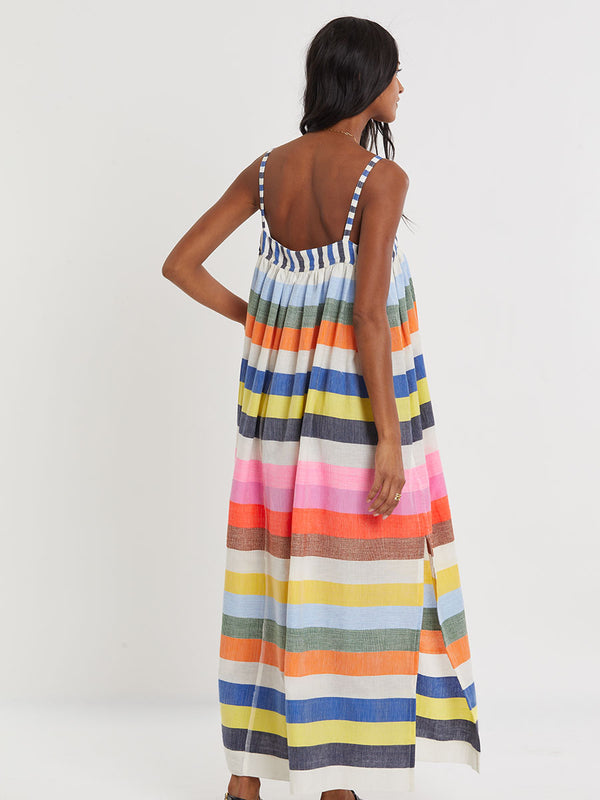 Woman wearing lemlem handwoven EDA Dress featuring bold, joyful stripe pattern in vibrant shades of blue, yellow, pink, orange, and green