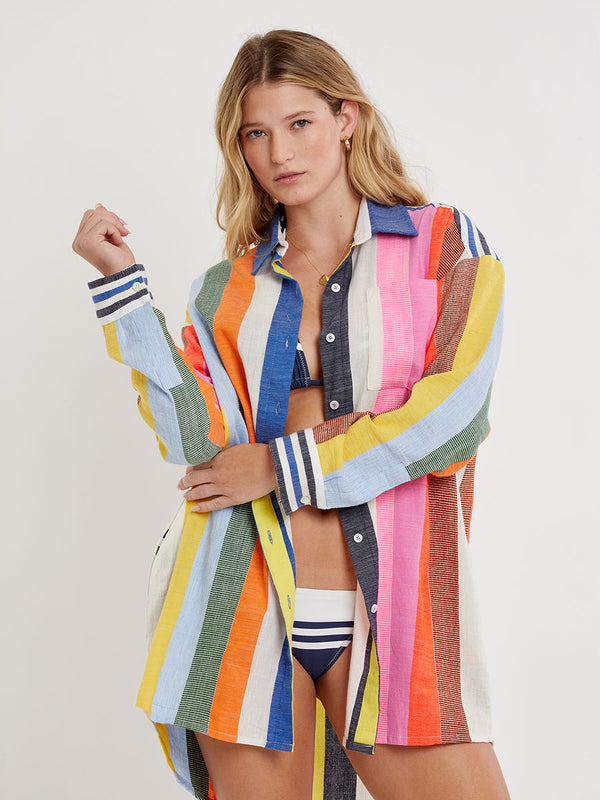 Woman wearing lemlem handwoven MARIAM Shirt featuring bold, joyful stripe pattern in vibrant shades of blue, yellow, pink, orange, and green