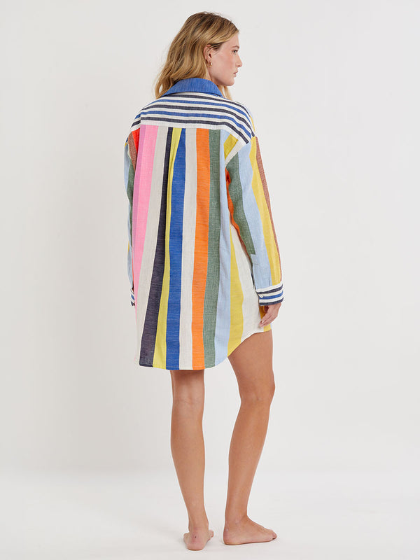 Woman wearing lemlem handwoven MARIAM Shirt featuring bold, joyful stripe pattern in vibrant shades of blue, yellow, pink, orange, and green