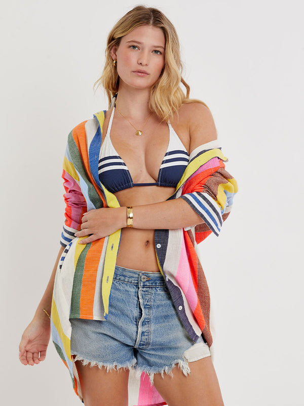 Woman wearing lemlem handwoven MARIAM Shirt featuring bold, joyful stripe pattern in vibrant shades of blue, yellow, pink, orange, and green