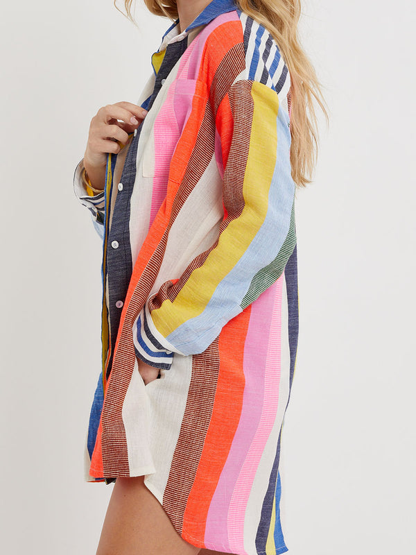 Woman wearing lemlem handwoven MARIAM Shirt featuring bold, joyful stripe pattern in vibrant shades of blue, yellow, pink, orange, and green