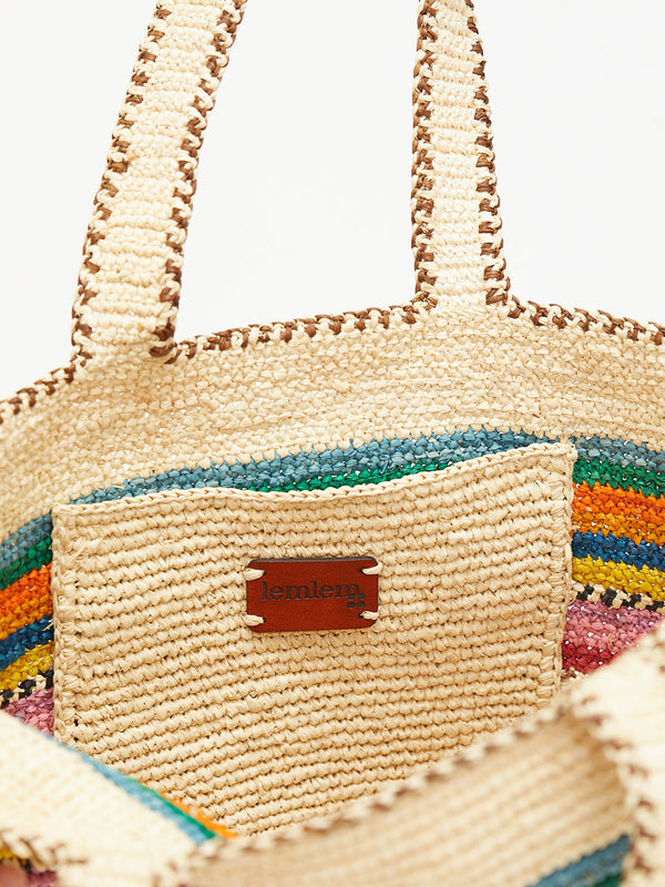 Woven lemlem MIRA Raffia bag with colorful stripes and a brand logo on a light background