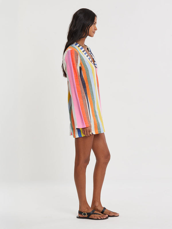Woman wearing lemlem RAEY Column Dress  featuring bold, joyful stripe pattern in vibrant shades of blue, yellow, pink, orange, and green
