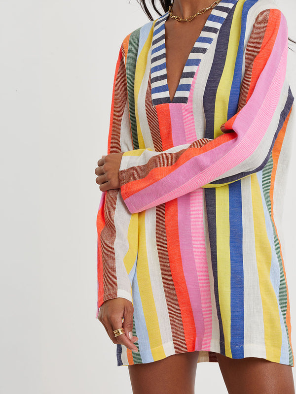 Woman wearing lemlem RAEY Column Dress  featuring bold, joyful stripe pattern in vibrant shades of blue, yellow, pink, orange, and green