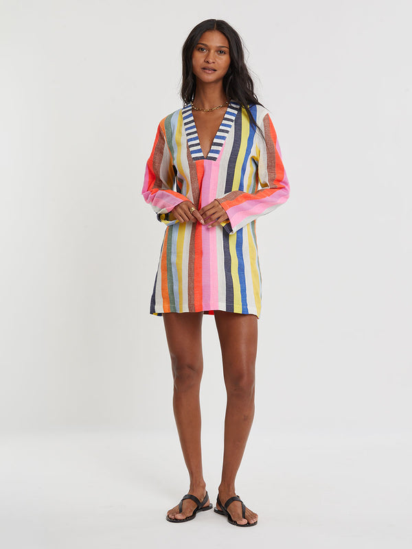 Woman wearing lemlem RAEY Column Dress  featuring bold, joyful stripe pattern in vibrant shades of blue, yellow, pink, orange, and green