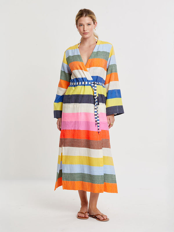 Woman wearing lemlem handwoven SHAWIT Long Robe featuring bold, joyful stripe pattern in vibrant shades of blue, yellow, pink, orange, and green