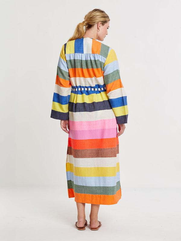 Woman wearing lemlem handwoven SHAWIT Long Robe featuring bold, joyful stripe pattern in vibrant shades of blue, yellow, pink, orange, and green