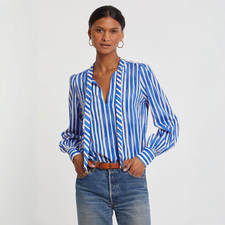 Woman standing wearing lemlem AZMERA Blouse featuring striped pattern in blue and white colors