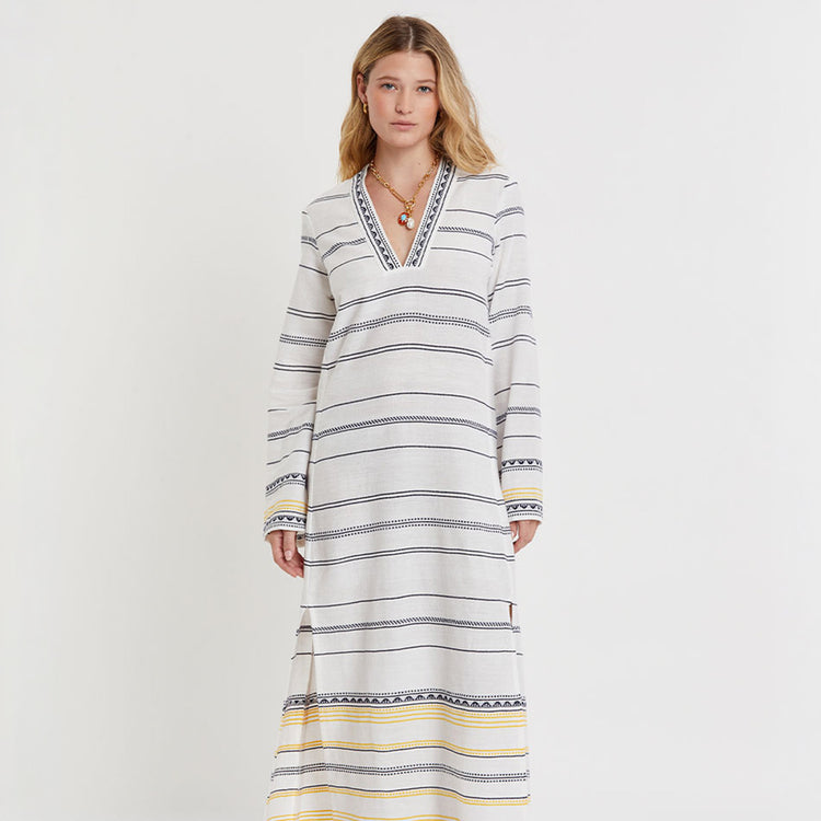 Woman wearing a long, striped lemlem handwoven THEODORA dress with a plain background
