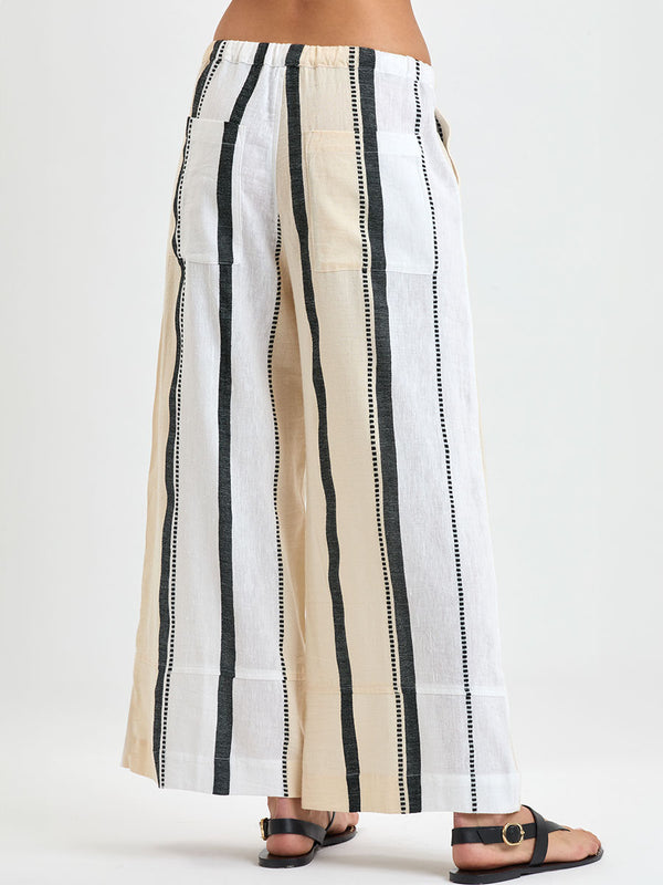 Close up on Woman's back standing wearing lemlem handwoven DESTA Pants  featuring  refined palette of crisp white, soft cream, and deep black