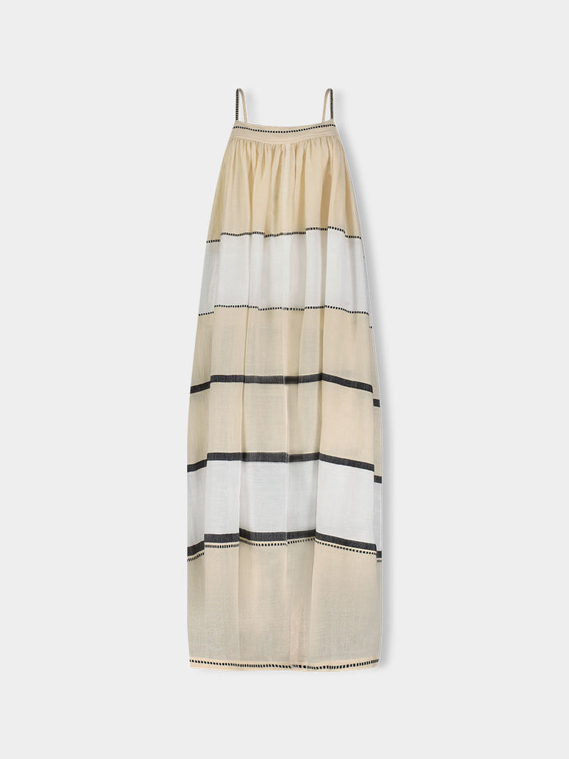 Woman standing wearing lemlem handwoven EDA Slip Dress featuring  refined palette of crisp white, soft cream, and deep black